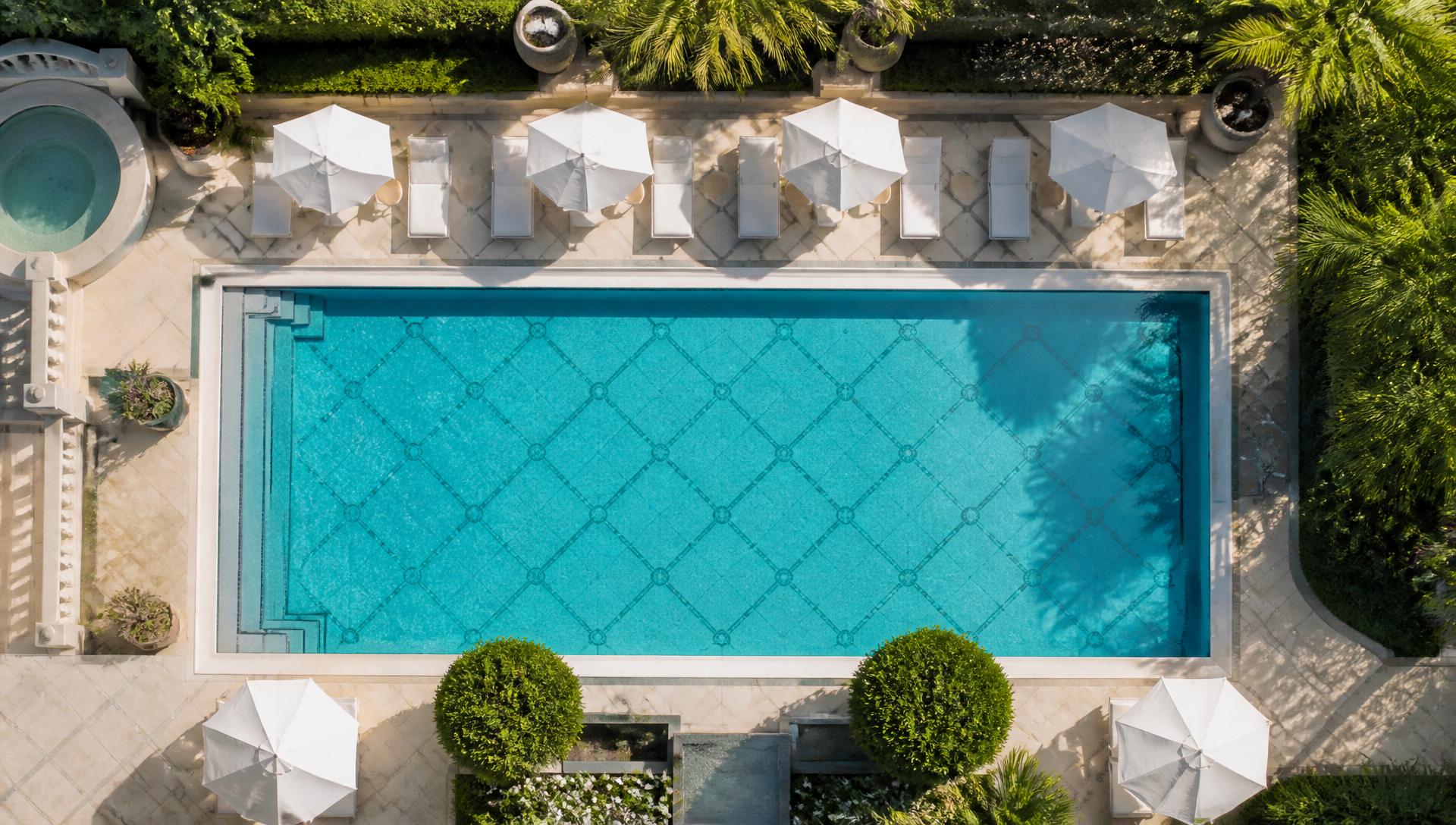 Aerial view of a geometric resort pool with sun loungers